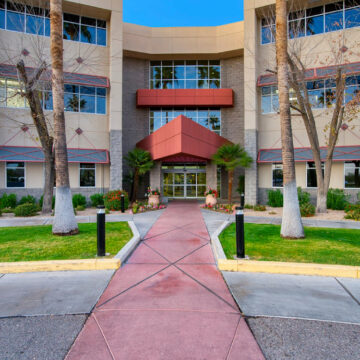 Modern Peak-Glendale building with red canopy and landscaped pathway.