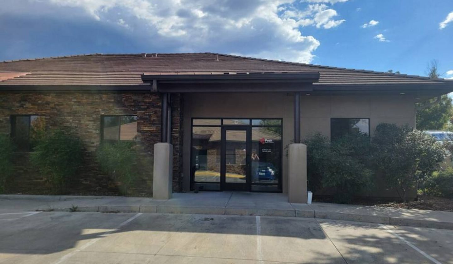Modern commercial building with accessible entrance and sustainable landscaping on a sunny day.